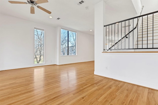 unfurnished living room with wood finished floors, baseboards, stairway, ceiling fan, and recessed lighting