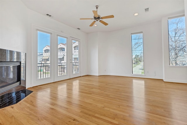 unfurnished living room with a tile fireplace, light wood-type flooring, a ceiling fan, baseboards, and recessed lighting