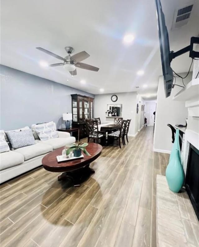 2112 Greenbriar Colony Dr, Houston, TX 77032 - living area with light wood finished floors, a ceiling fan, a fireplace, baseboards, and recessed lighting