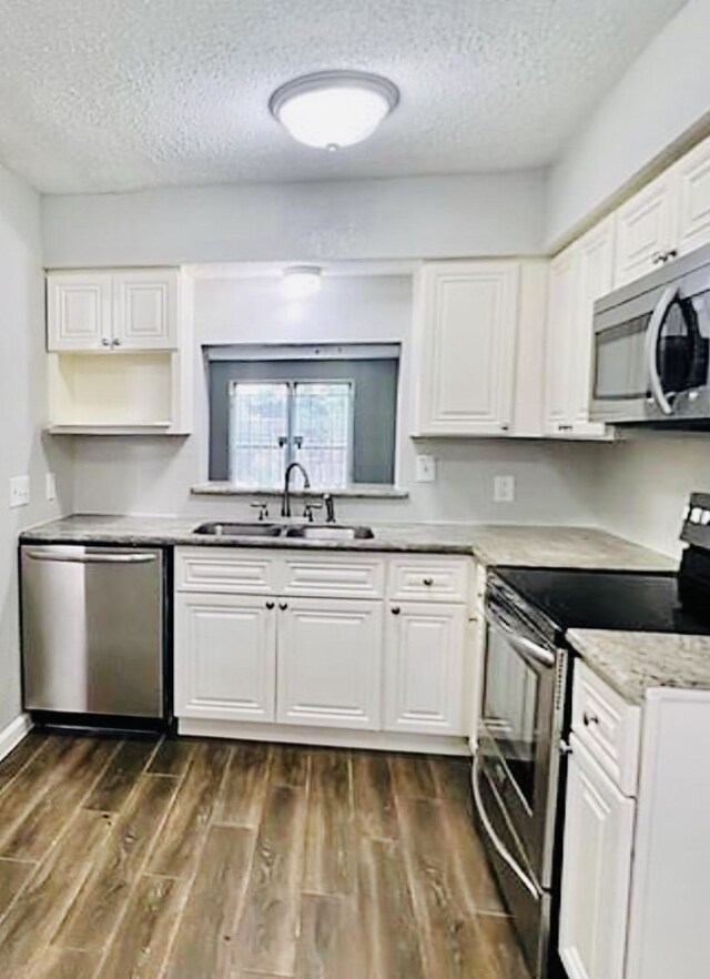 2112 Greenbriar Colony Dr, Houston, TX 77032 - kitchen featuring appliances with stainless steel finishes, a sink, a textured ceiling, white cabinetry, and dark wood finished floors