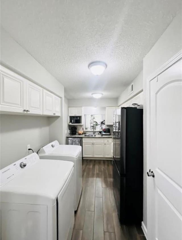 2112 Greenbriar Colony Dr, Houston, TX 77032 - clothes washing area with washing machine and dryer, dark wood-style floors, and a textured ceiling