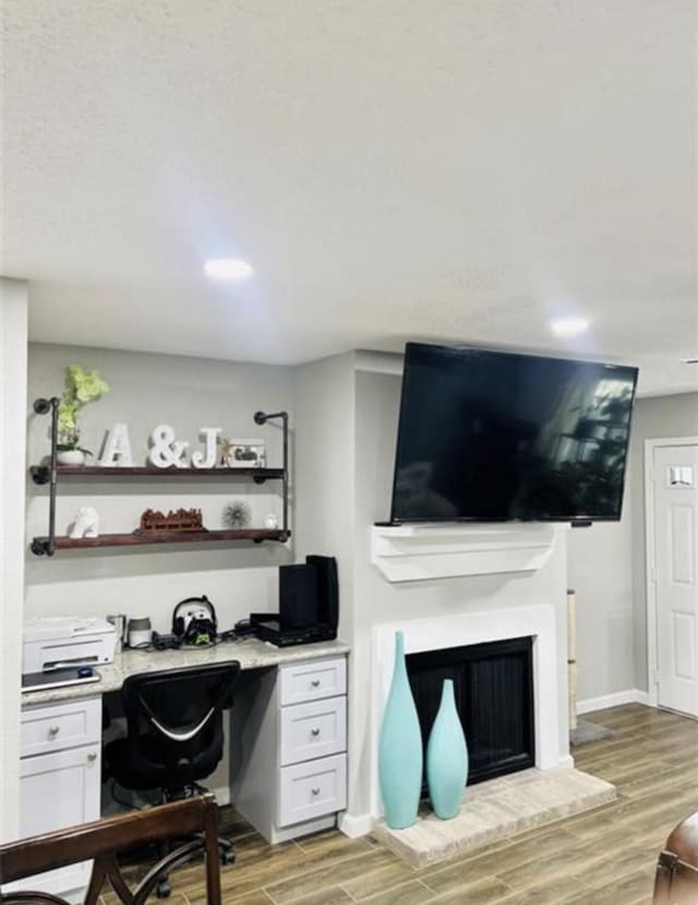2112 Greenbriar Colony Dr, Houston, TX 77032 - office area featuring light wood-style flooring, built in study area, baseboards, and a fireplace