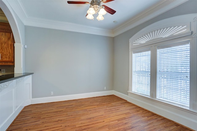 2709 Blodgett St, Houston, TX 77004 - unfurnished dining area featuring light wood-style flooring, ceiling fan, arched walkways, crown molding, and baseboards