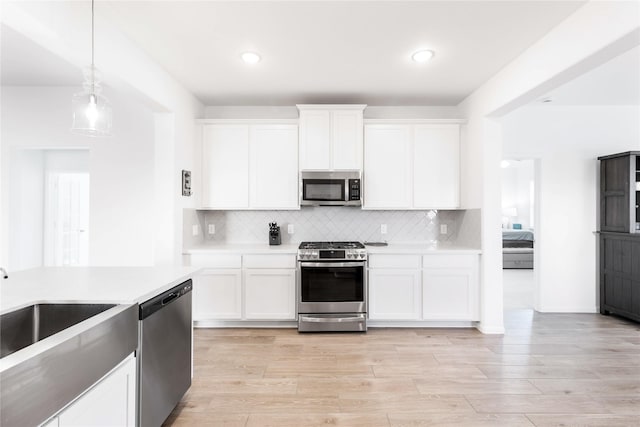 7111 Hillside Ave, Baytown, TX 77523 - kitchen with appliances with stainless steel finishes, light countertops, white cabinetry, tasteful backsplash, and recessed lighting