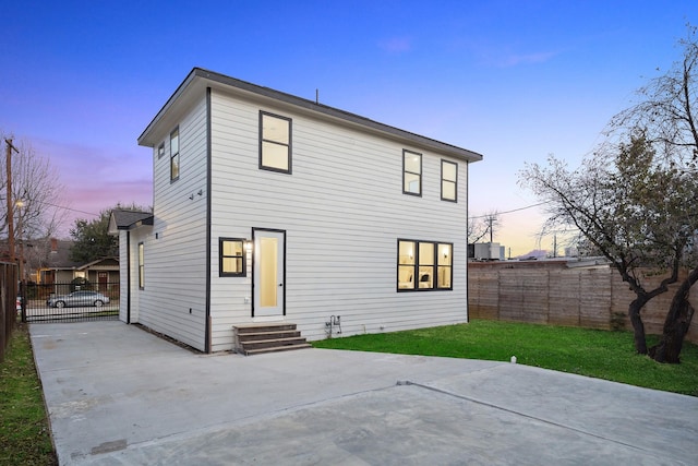 2611 Morrison St, Houston, TX 77009 - back of property at dusk featuring entry steps, a patio area, and driveway