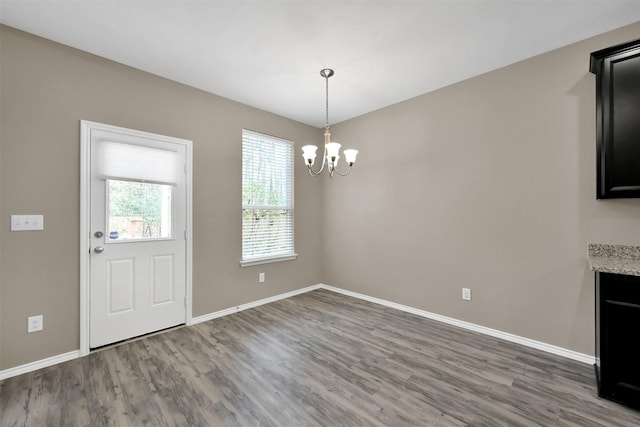 foyer featuring wood finished floors, a chandelier, and baseboards