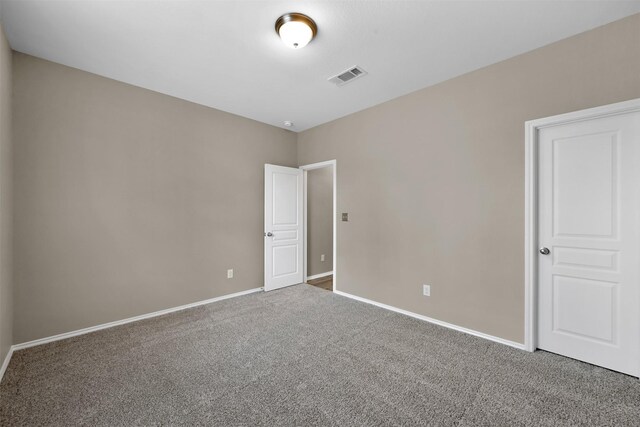 spare room featuring carpet floors and baseboards