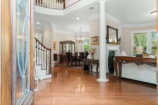 2 Argonne Pl, The Woodlands, TX 77382 - entrance foyer featuring ornate columns, stairs, wood finished floors, a chandelier, and crown molding