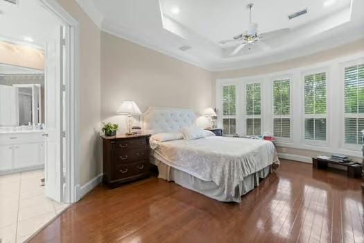 2 Argonne Pl, The Woodlands, TX 77382 - bedroom featuring multiple windows, wood finished floors, a raised ceiling, and baseboards