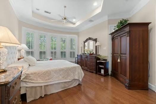 2 Argonne Pl, The Woodlands, TX 77382 - bedroom featuring wood finished floors, a raised ceiling, crown molding, and a ceiling fan