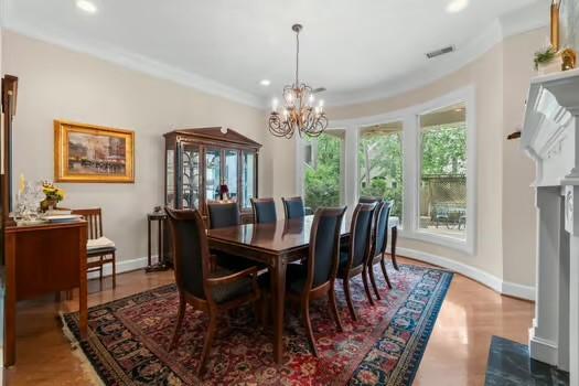 2 Argonne Pl, The Woodlands, TX 77382 - dining area featuring a chandelier, recessed lighting, ornamental molding, a fireplace with flush hearth, and baseboards