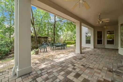 2 Argonne Pl, The Woodlands, TX 77382 - view of patio / terrace with a ceiling fan, outdoor dining space, and view of scattered trees
