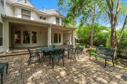2 Argonne Pl, The Woodlands, TX 77382 - back of property featuring stucco siding, outdoor dining space, and a patio area