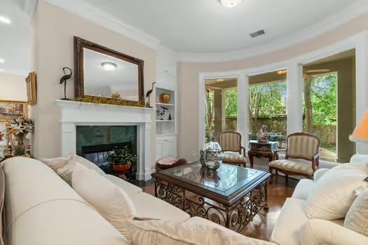 2 Argonne Pl, The Woodlands, TX 77382 - living room with healthy amount of natural light, wood finished floors, crown molding, and a glass covered fireplace