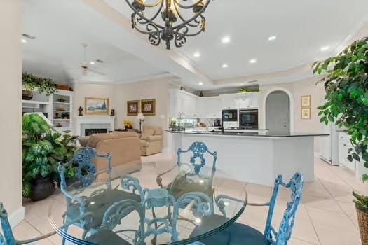 2 Argonne Pl, The Woodlands, TX 77382 - dining space featuring arched walkways, a chandelier, a fireplace, light tile patterned floors, and recessed lighting