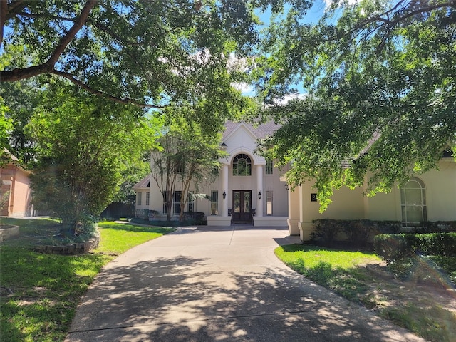 2 Argonne Pl, The Woodlands, TX 77382 - view of front of home with french doors, stucco siding, and a front lawn