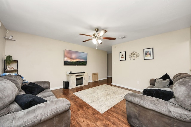 living area with ceiling fan, dark wood-style flooring, and baseboards