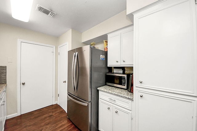 kitchen featuring stainless steel appliances, dark wood finished floors, white cabinetry, and light stone countertops