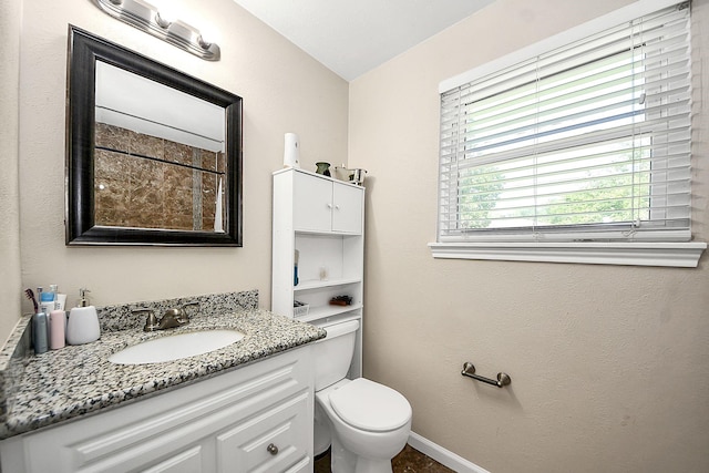 bathroom with vanity, toilet, and baseboards