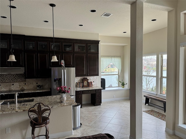 24130 Cannon Anello Ct, Katy, TX 77493 - kitchen featuring stainless steel fridge with ice dispenser, a sink, decorative backsplash, light stone countertops, and pendant lighting