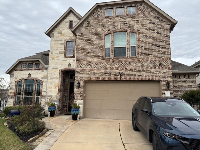24130 Cannon Anello Ct, Katy, TX 77493 - french country home with concrete driveway, brick siding, stone siding, and an attached garage