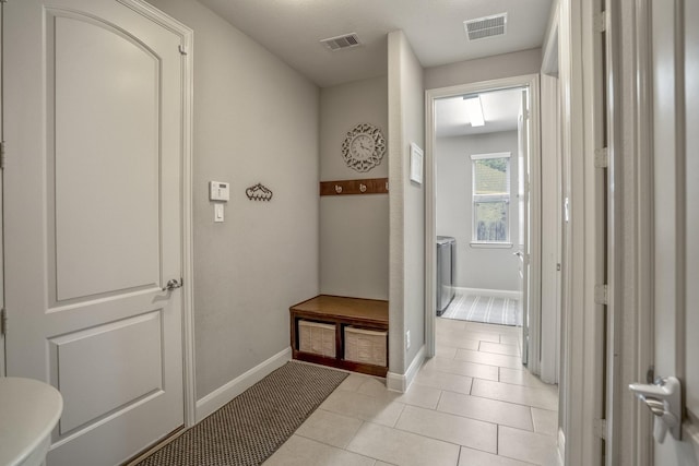 mudroom featuring light tile patterned floors and baseboards