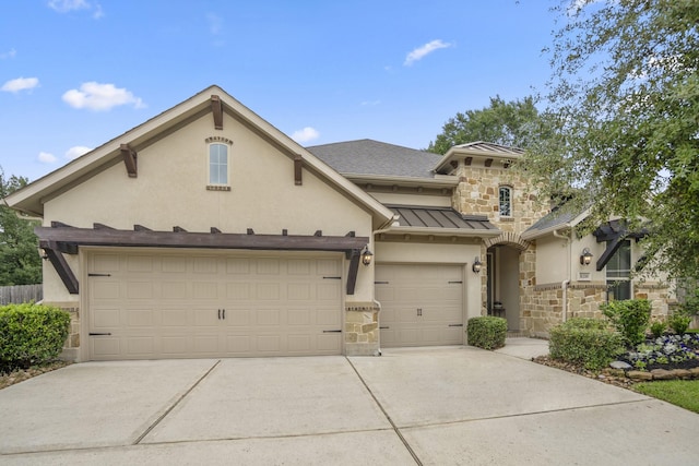 view of front of home with stone siding, driveway, and stucco siding