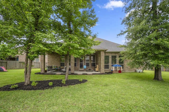 back of property with brick siding, a patio, and roof with shingles