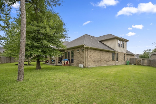 back of house featuring brick siding and roof with shingles