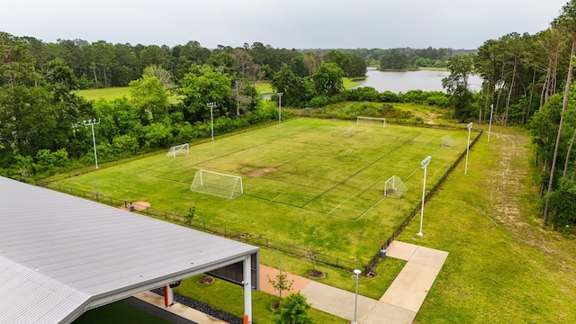 drone / aerial view of a nearby body of water and a heavily wooded area