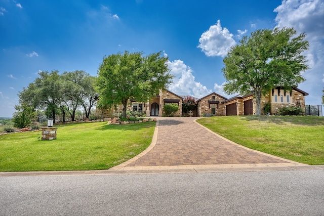143 Westgate Loop, Horseshoe Bay, TX 78657 - view of front of property featuring a front yard, an attached garage, driveway, and stone siding