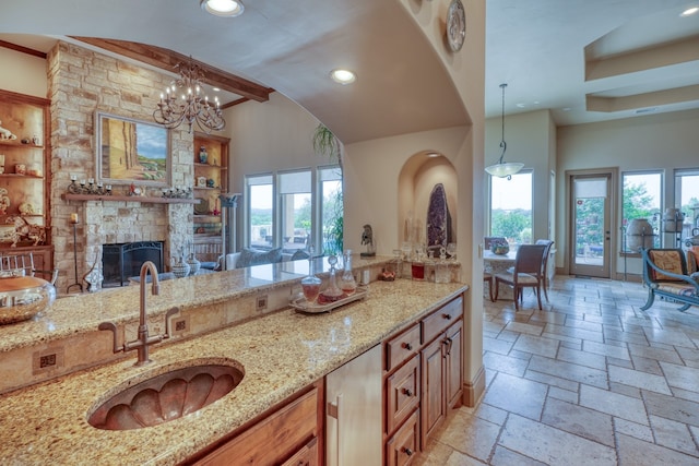 143 Westgate Loop, Horseshoe Bay, TX 78657 - kitchen featuring a sink, light stone countertops, recessed lighting, stone tile flooring, and decorative light fixtures
