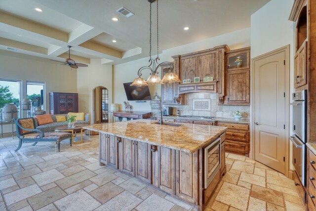 143 Westgate Loop, Horseshoe Bay, TX 78657 - kitchen featuring a towering ceiling, recessed lighting, coffered ceiling, stone tile floors, and arched walkways