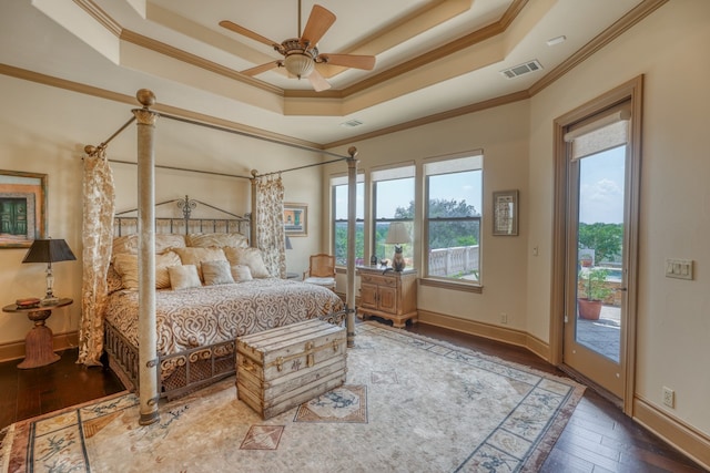 143 Westgate Loop, Horseshoe Bay, TX 78657 - bedroom with a tray ceiling, ornamental molding, access to outside, hardwood / wood-style floors, and baseboards