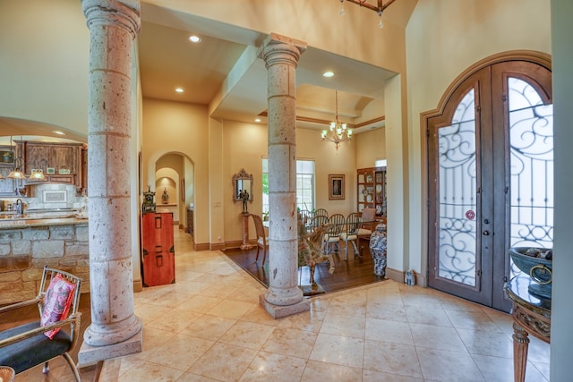 143 Westgate Loop, Horseshoe Bay, TX 78657 - foyer with decorative columns, french doors, a high ceiling, arched walkways, and light tile patterned floors