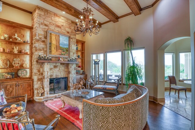143 Westgate Loop, Horseshoe Bay, TX 78657 - living area with beamed ceiling, arched walkways, dark wood-style floors, a fireplace, and a chandelier