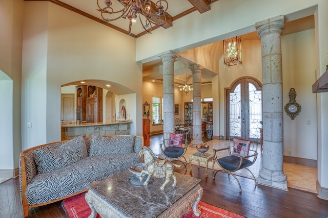 143 Westgate Loop, Horseshoe Bay, TX 78657 - living area featuring a chandelier, a high ceiling, hardwood / wood-style flooring, baseboards, and french doors