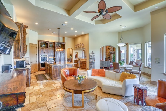 143 Westgate Loop, Horseshoe Bay, TX 78657 - living room with arched walkways, a high ceiling, coffered ceiling, recessed lighting, and ceiling fan