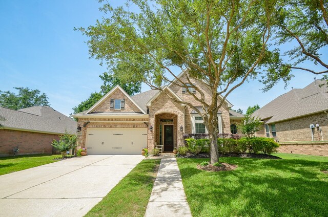 1523 Cafe Dumonde, Conroe, TX 77304 - view of front of home featuring brick siding, driveway, a front yard, and a garage