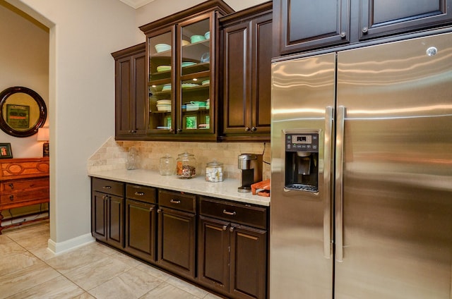 1523 Cafe Dumonde, Conroe, TX 77304 - kitchen featuring stainless steel refrigerator with ice dispenser, tasteful backsplash, dark brown cabinets, glass insert cabinets, and crown molding