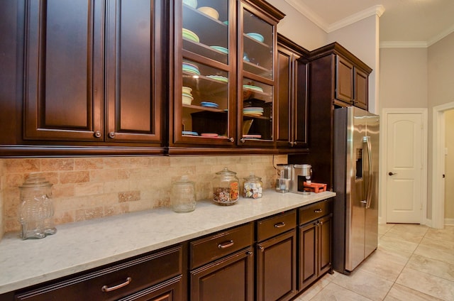 1523 Cafe Dumonde, Conroe, TX 77304 - kitchen with stainless steel fridge, decorative backsplash, ornamental molding, dark brown cabinets, and light tile patterned flooring
