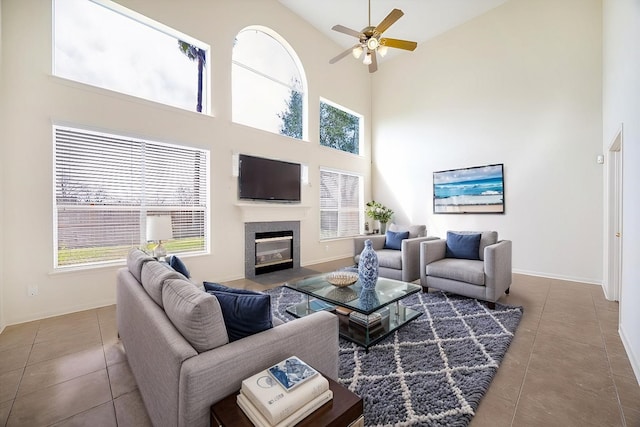 15027 Moss Bridge Ln, Sugar Land, TX 77498 - living area with tile patterned flooring, high vaulted ceiling, ceiling fan, a fireplace with flush hearth, and baseboards