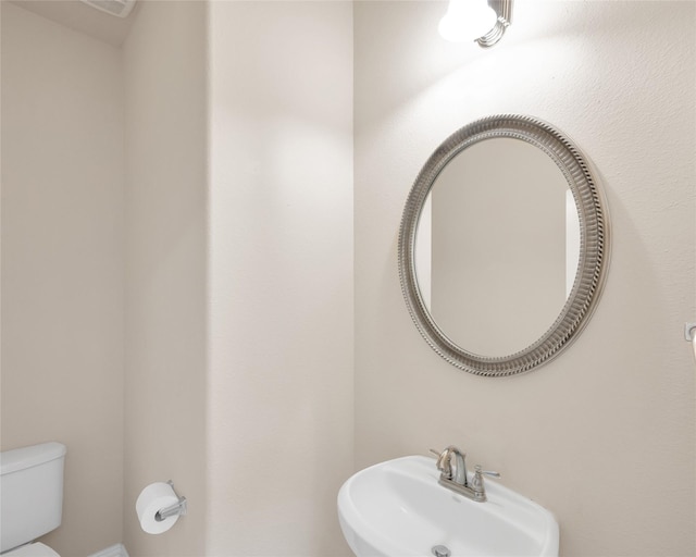 half bathroom with a sink and toilet