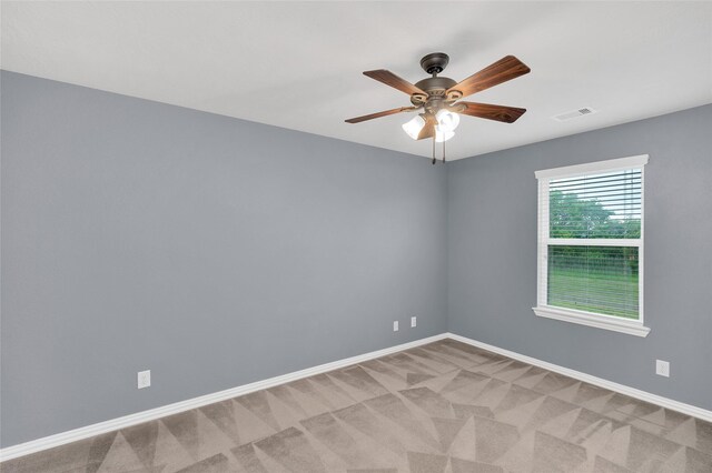 unfurnished room with baseboards, a ceiling fan, and light colored carpet