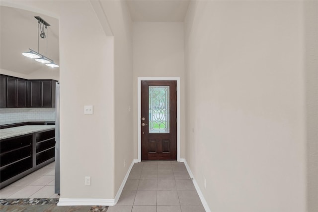 entryway with light tile patterned flooring and baseboards