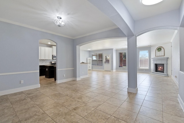 19107 Egret Glen Ct, Cypress, TX 77429 - unfurnished living room with light tile patterned floors, a glass covered fireplace, ornamental molding, baseboards, and arched walkways