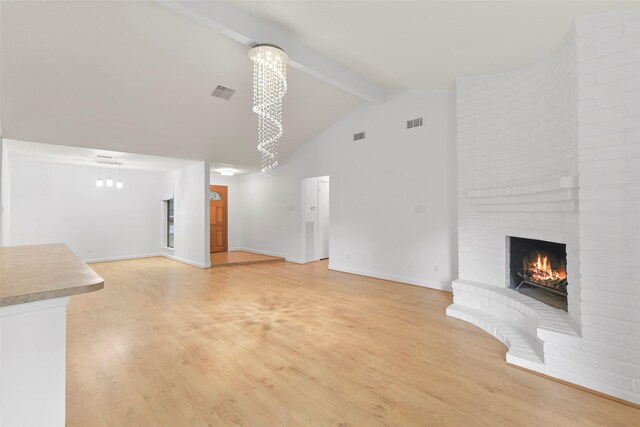unfurnished living room with beamed ceiling, high vaulted ceiling, light wood-style floors, a fireplace, and baseboards