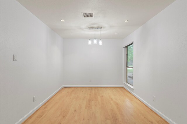 empty room featuring light wood finished floors, baseboards, and recessed lighting