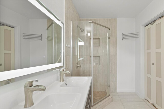 full bath featuring a stall shower, tile patterned flooring, and double vanity