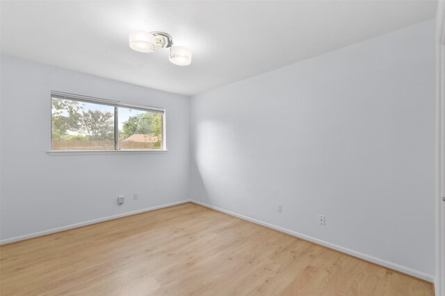 empty room featuring light wood-style flooring and baseboards